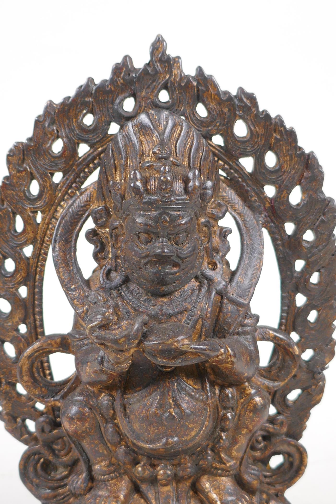 A Sino Tibetan gilt bronze figure of a wrathful deity standing on a figure, impressed double vajra - Image 2 of 4