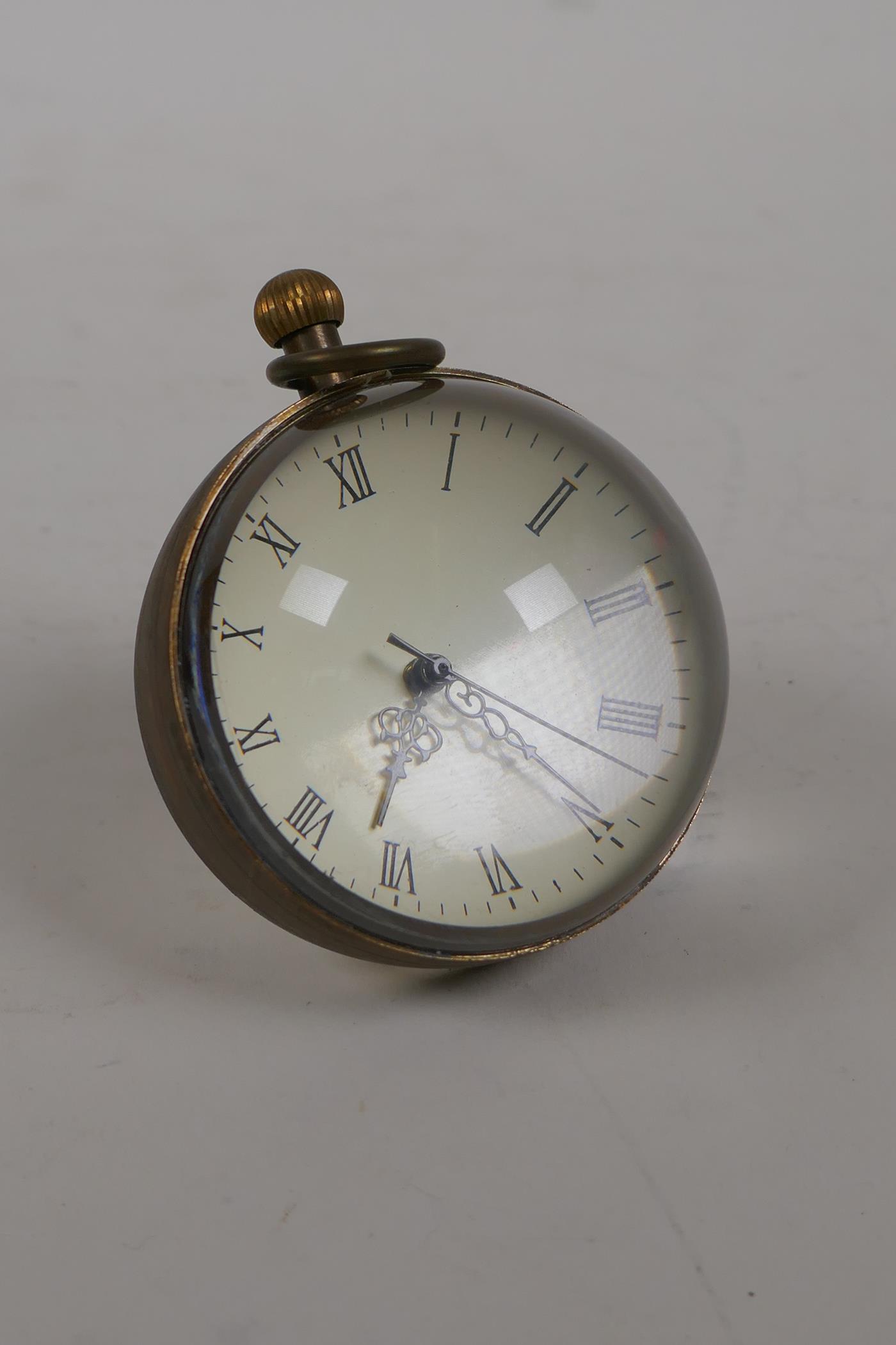 A brass and glass ball desk clock, 2½" diameter