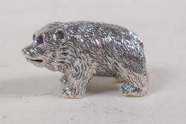 A miniature silver bear figure with blue stone set eyes, 3cm long