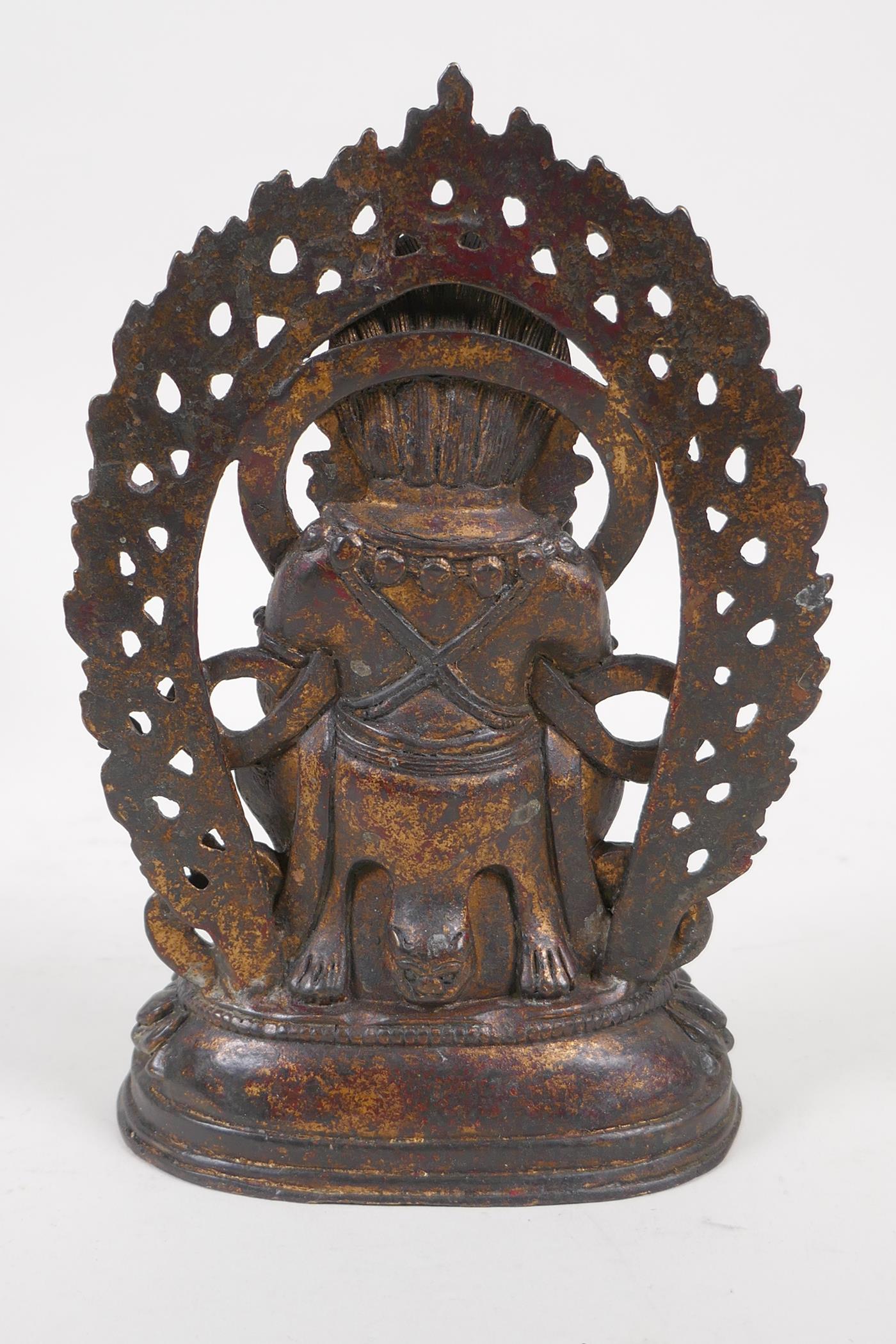 A Sino Tibetan gilt bronze figure of a wrathful deity standing on a figure, impressed double vajra - Image 3 of 4