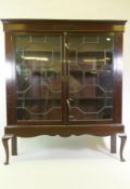 A C19th mahogany display cabinet with astragal glazed doors, raised on a base with cabriole supports