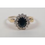 A 9ct yellow gold ring set with a blue stone encircled by diamonds, size Q/R