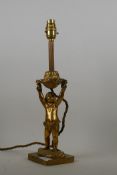 An antique brass table lamp in the form of a cherub, 40cm high