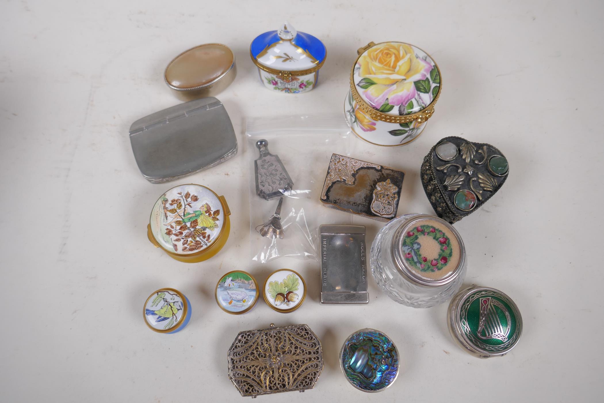 A collection of trinket, pill and match boxes including ceramic, glass and metal, and a small silver