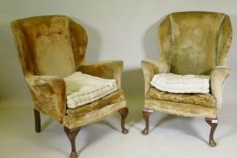 A pair of mid century wing back armchairs, raised on cabriole supports