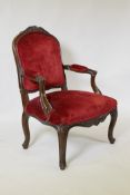 A Louis XV style open arm chair, with carved crest, raised on cabriole supports