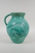 A Susie Cooper green glazed Art Deco studio pottery jug with incised ram and deer design signed to