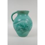 A Susie Cooper green glazed Art Deco studio pottery jug with incised ram and deer design signed to
