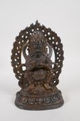 A Sino Tibetan gilt bronze figure of a wrathful deity standing on a figure, impressed double vajra