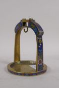 A brass stirrup with inset cloisonne decoration, 15cm high