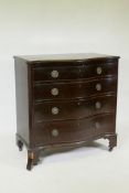 A mahogany serpentine front chest of four long drawers, with canted sides, oak linings and