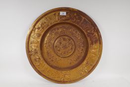 A gilded cast iron wall plaque with classical decoration, 50cm diameter