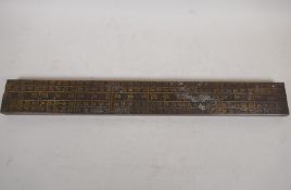 A Chinese metal wrapped scroll weight / measure decorated with calligraphy, 18" long