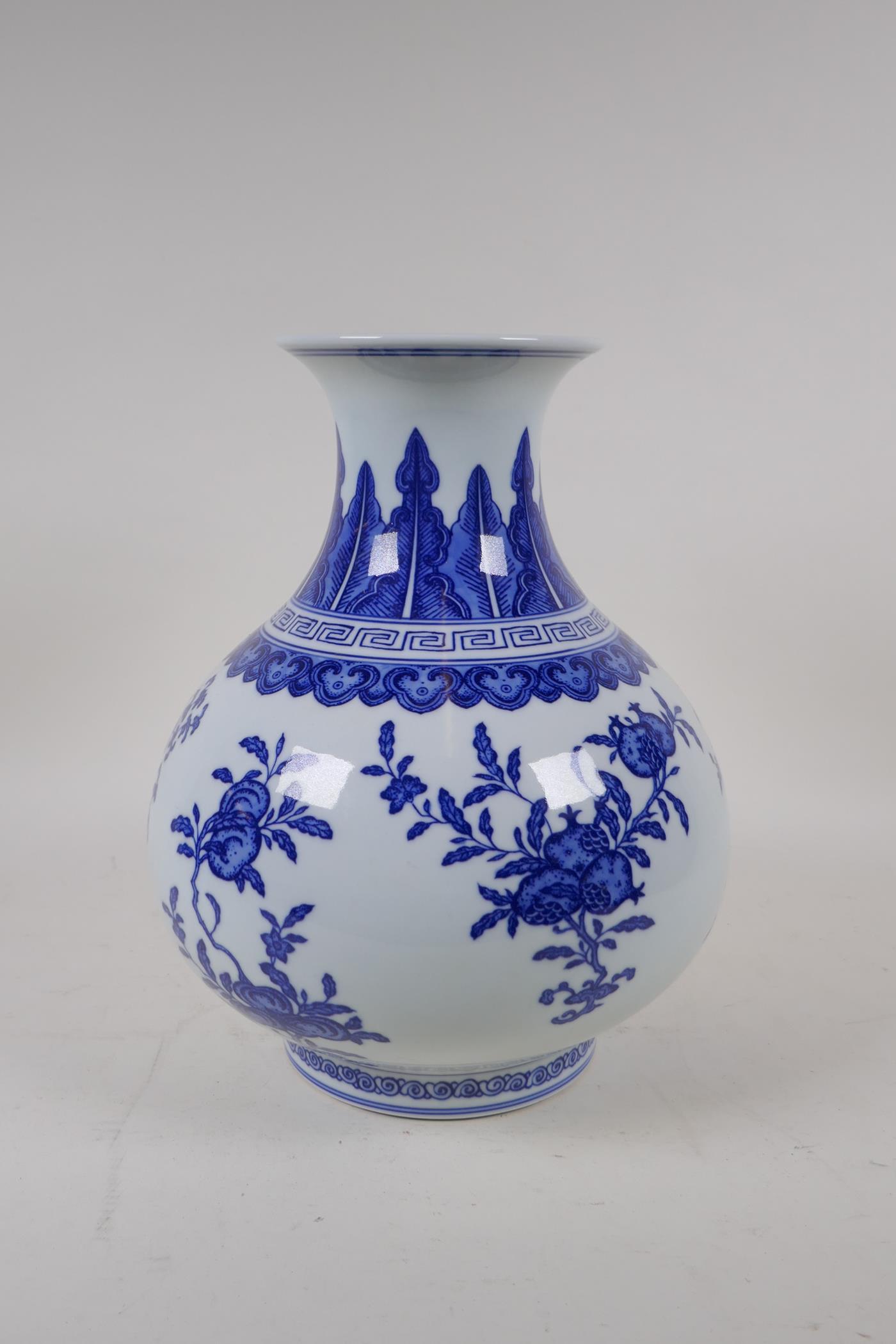 A blue and white porcelain vase decorated with flowers and fruiting peach and pomegranate trees, - Image 2 of 6