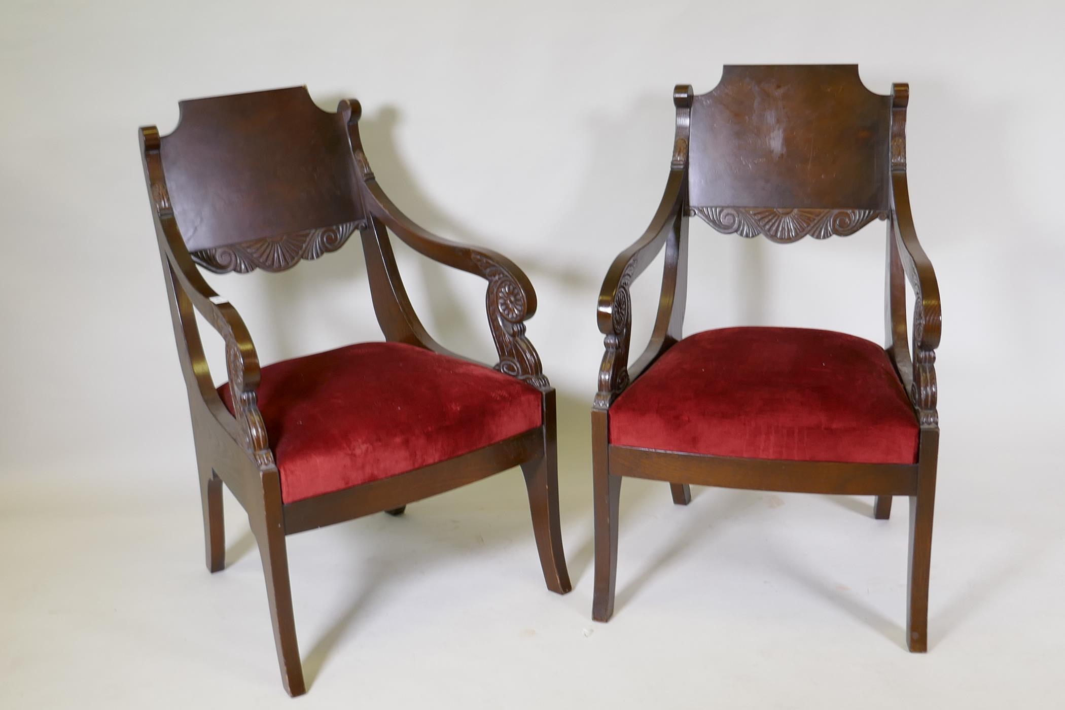 A pair of oak Empire style open arm chairs with carved decoration, late C20th, 92cm high