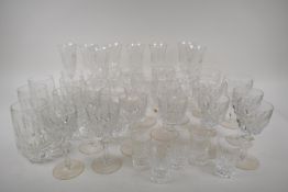 A suite of crystal drinking glasses to include Champagne flutes, wine and sherry stem glasses,