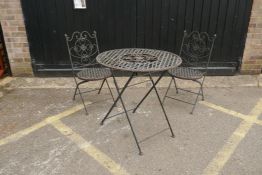 A vintage French style metal folding bistro table and two chairs, table 76cm diameter