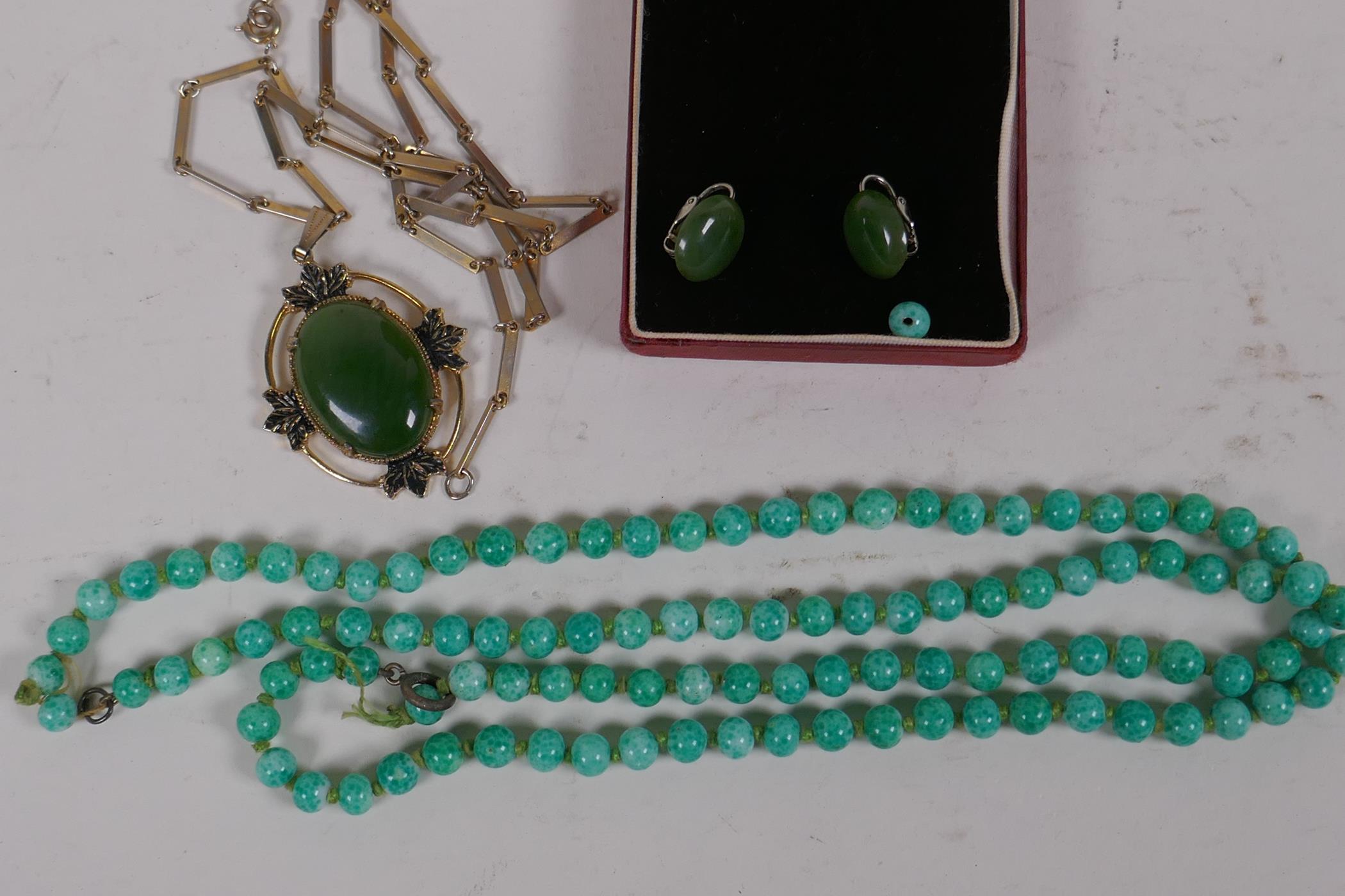 A suite of gilt metal and jade earrings and pendant, and a string of jade beads