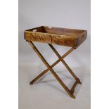 A steamer style butler's tray on folding stand, the tray bearing the names London, Paris, New York