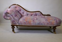 A Victorian walnut chaise longue with carved shaped back, raised on carved and turned supports