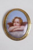 A pinchbeck gold brooch inset with a porcelain panel, finely painted cherub after Raphael, 6cm long