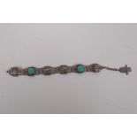 An Indian white metal and turquoise bracelet decorated with elephants and the hand of fatima, 21cm