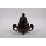 A Chinese bronze two handled censer and cover, with dragon knop and handles, raised on tripod