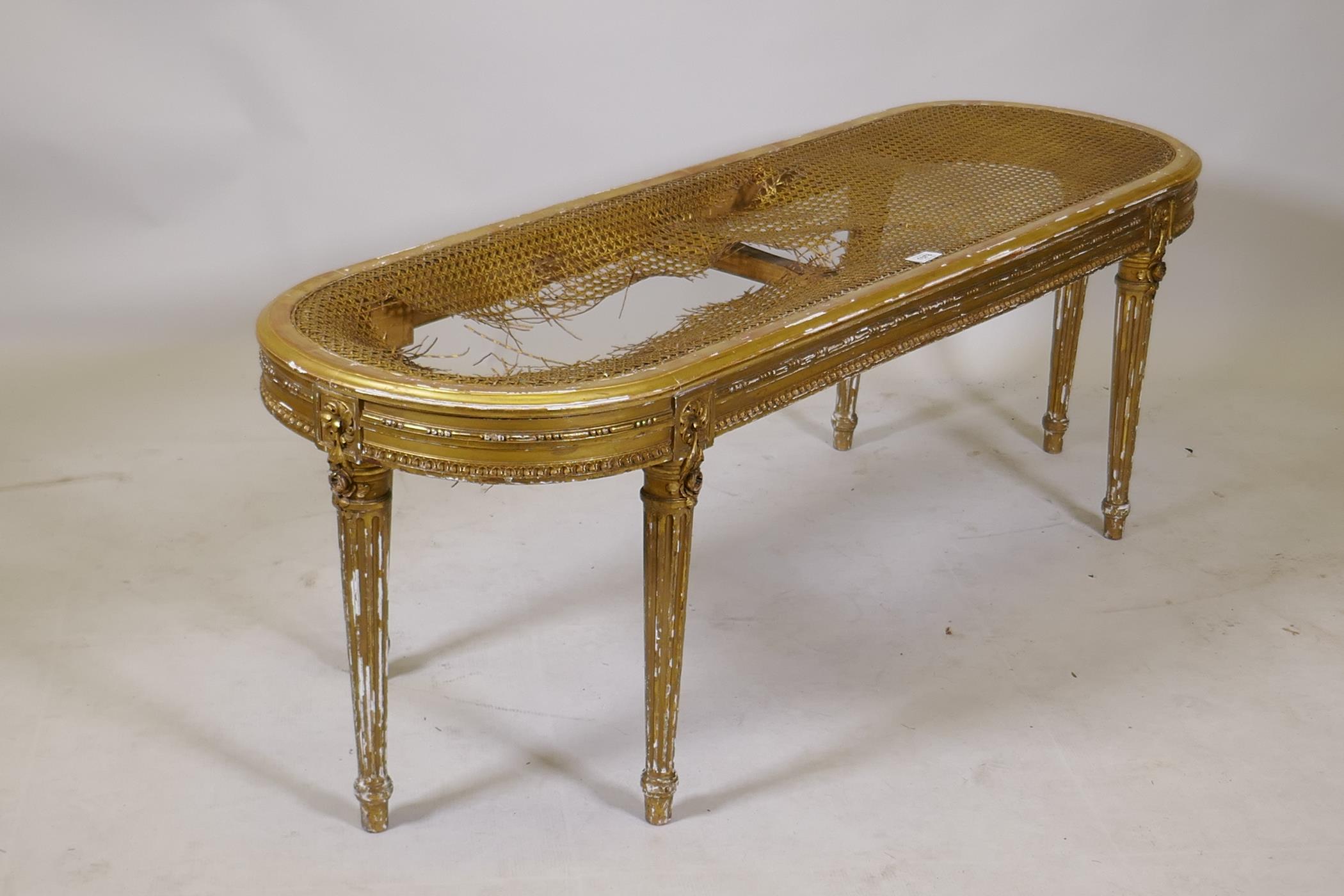 A C19th gilt wood window seat with oval cane top on six fluted supports, cane AF, 45 x 132 x 43cms - Image 3 of 3