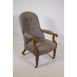 A Victorian mahogany open arm chair with button back and scrolled arms, raised on turned supports