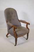 A Victorian mahogany open arm chair with button back and scrolled arms, raised on turned supports