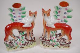 A pair of Staffordshire flat back spill vases modelled as foxes with birds in their mouths, 25cm