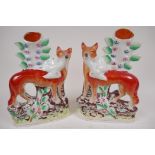 A pair of Staffordshire flat back spill vases modelled as foxes with birds in their mouths, 25cm