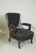 A Victorian show frame rosewood arm chair, with carved arms, raised on turned supports with brass