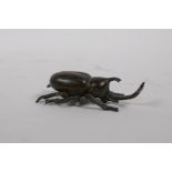 A Japanese style bronze okimono rhinoceros beetle, 8cm long