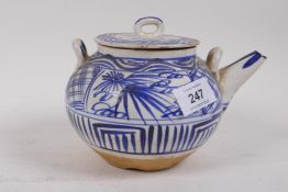 Oriental terracotta tea pot with blue and white glazed decoration, inscribed to the spout, 12cm high