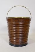 A fruitwood peat bucket with ebonised base and brass handle and liner, 33cm high