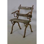 An antique wrought iron single seat garden chair, the cast ends of organic form, with worn wood