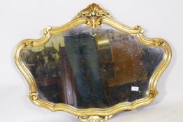 A gilt composition shaped wall mirror, 91 x 70cms
