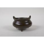 A Chinese bronze censer with two phoenix eye handles and tripod feet, 4 character mark to base, 10cm