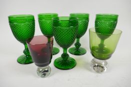 A set of five green pressed glass wine goblets with hobnail design, 16cm, together with two coloured