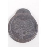 A Chinese bronze pendant decorated with running horses, the reverse with calligraphy, 10cm diameter