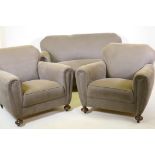 An Art Deco three piece suite, settee and two armchairs, well upholstered in a neutral fabric, 145cm