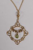 A 9ct gold pendant set with seed pearls and a green stone on a gilt chain, 3.8g