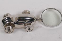 A desk top magnifying glass, the handle in the form of a silver plated racing car, 23cm long
