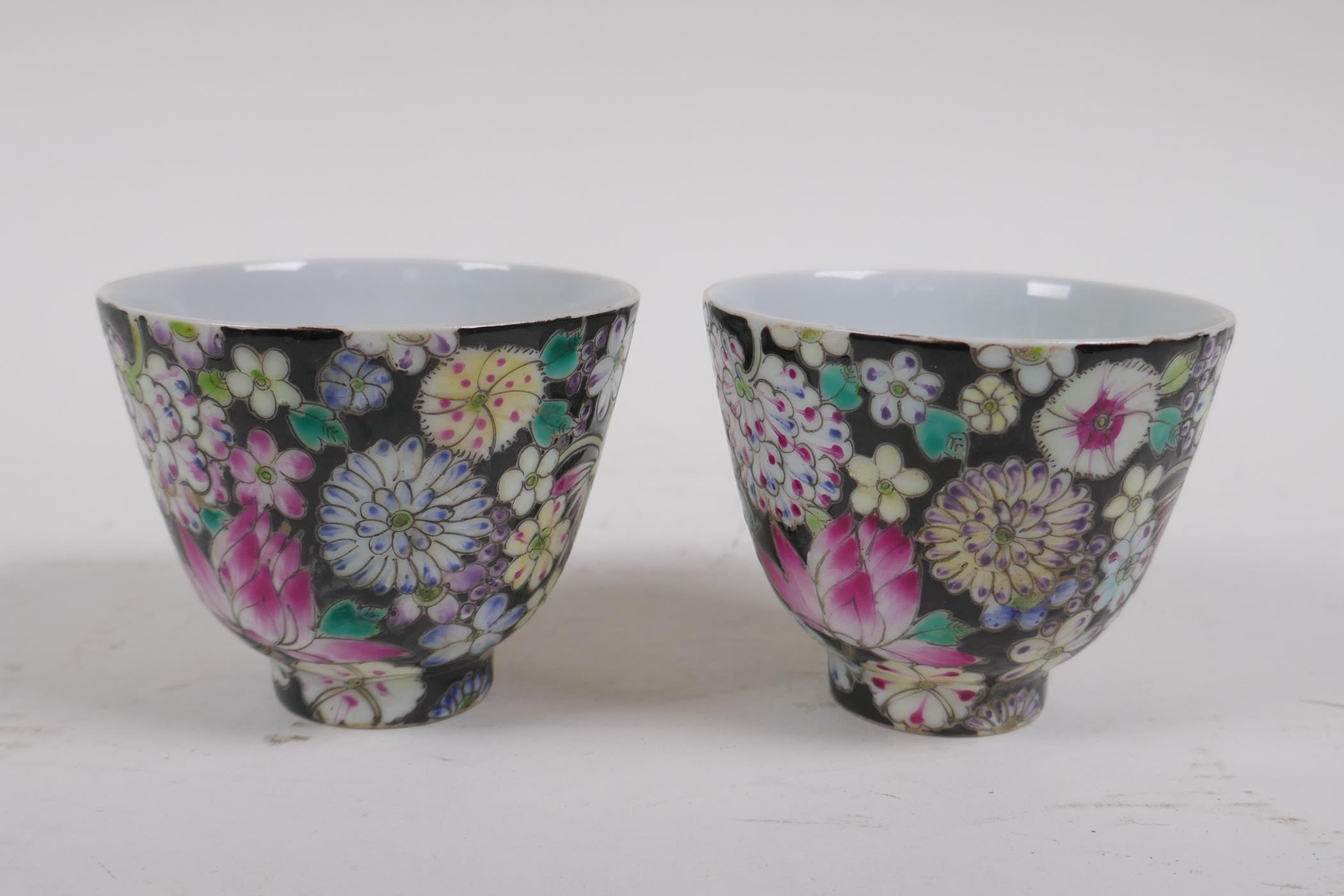 A pair of late C19th/early C20th famille noir porcelain tea bowls with floral decoration, Chinese