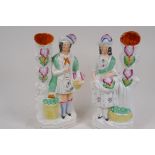 A pair of Staffordshire flat back spill vases modelled as a Scottish lady and gentleman, 27cm high