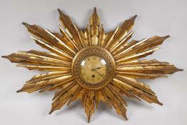 A 1930s carved and gilt wood cased sunburst wall clock, with French timepiece movement and Arabic