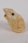 A carved bone okimono in the form of a frog, 6cm high