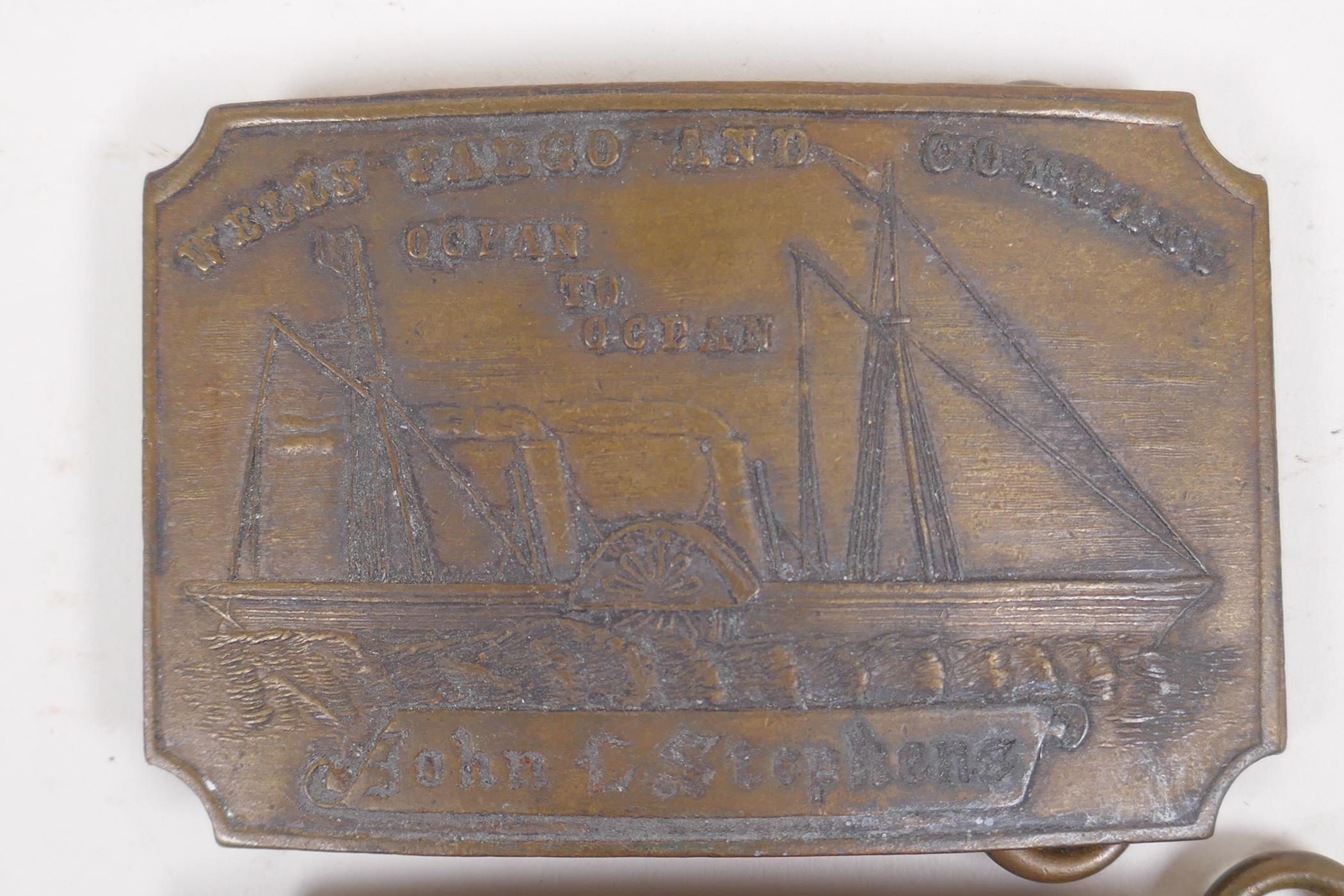 A pair of Tiffany style brass belt buckles advertising 'Wells Cargo' and 'Union Central', 9 x 6cm - Image 2 of 3