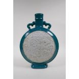 An emerald green glazed porcelain two handled moon flask with a white ground panel and raised dragon